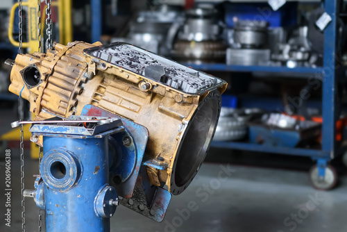Tableau sur toile A heavy industrial yellow transmission unit with open valve body mounted on a blue fixture stand inside a workshop