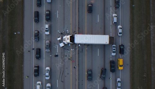Obraz na płótnie An aerial view of a major highway accident involving a jackknifed semi-truck causing a significant traffic jam on a multi-lane road