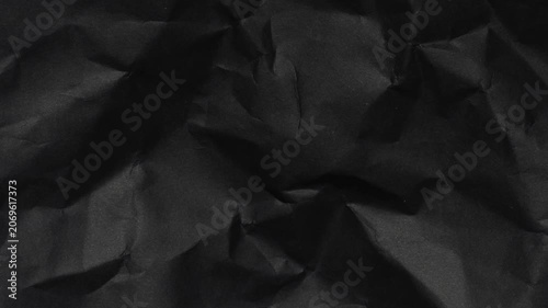 grunge crumpled black paper texture. worn out dark texture with shadows and light