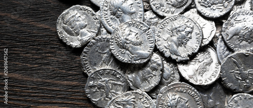 Εκτύπωση καμβά Top view of ancient silver coins on a dark wooden board