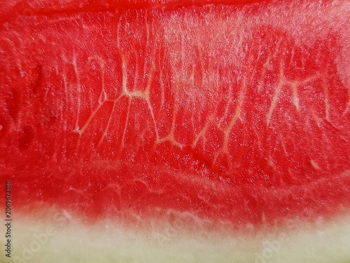 A macro close-up texture of a fresh red juicy watermelon flesh with seeds, perfect for a vibrant summer background, food backdrop, or bright wallpaper