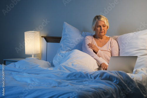 Senior woman with laptop su...