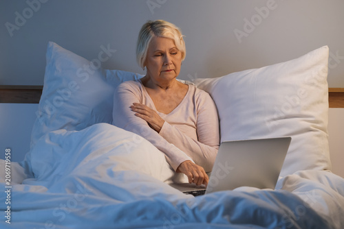 Senior woman with laptop su...