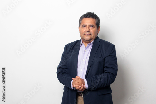 60-year-old Latino man with dark skin appears happy and at peace, enjoying a successful professional and personal life