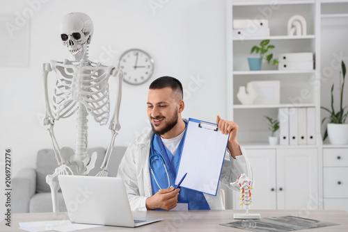 Male doctor with clipboard ...