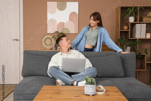 Young couple using laptop at home