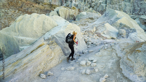 Woman Hiking Through Rocky Terrain at Ijen Crater, Banyuwangi Indonesia.