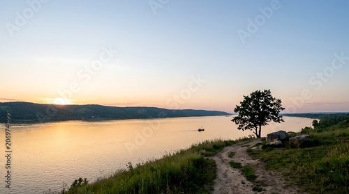 Scenic sunset over a wide river with a lone tree on the bank