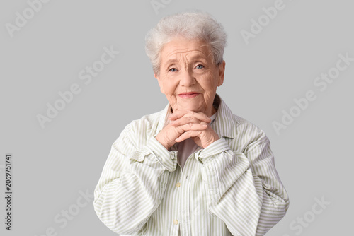 Senior woman on grey background