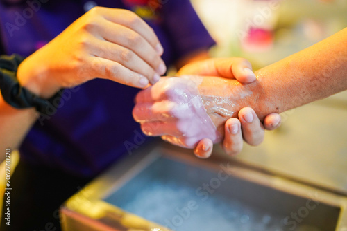 Therapist applying paraffin wax treatment on hand
