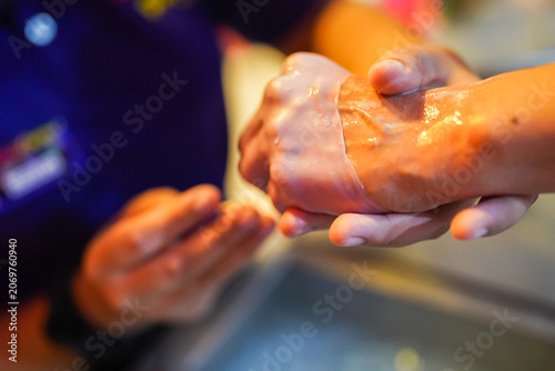 Person receiving paraffin wax hand spa treatment