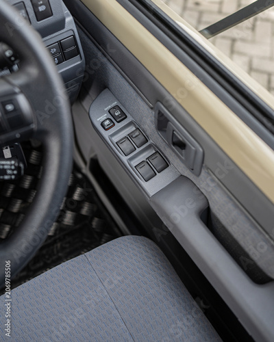 Car interior door control panel with window switches closeup view.