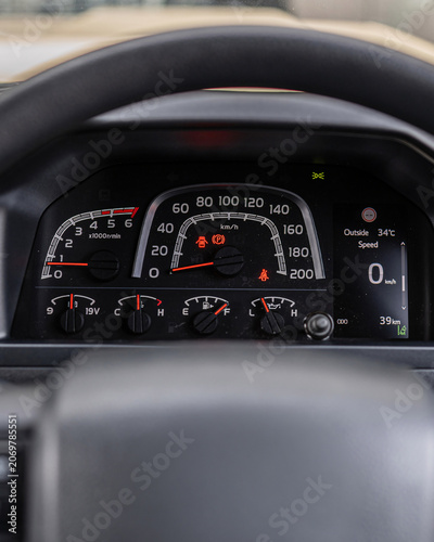 Close up car dashboard with speedometer tachometer gauges.
