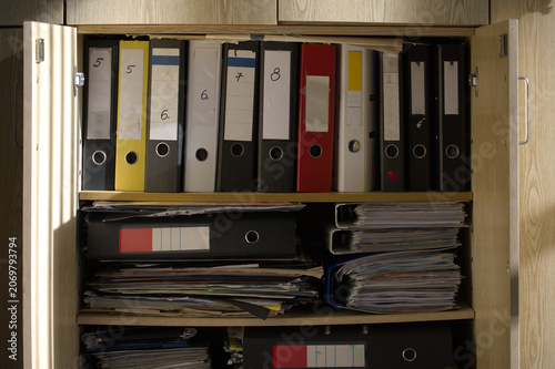 Cabinet filled with files and documents inside an office space.