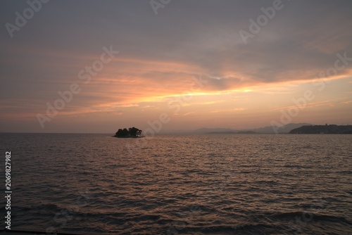 Sunset over sea with island silhouette in early summer, Japan
