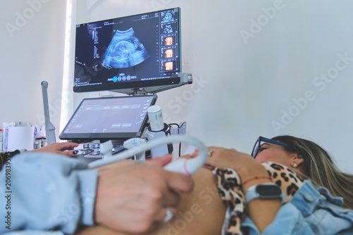 Pregnant woman receiving medical ultrasound scan for prenatal care