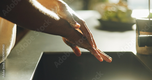 Fotografie Washing, hands and person in home for hygiene, cleanliness and remove dirt for disinfection