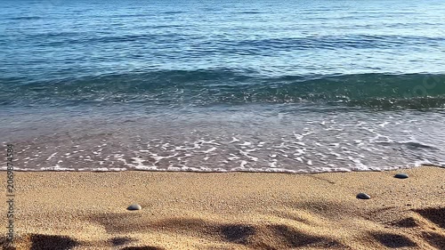 Serene Tropical Beach Landscape Featuring Gentle Blue Ocean Waves Rolling Onto Soft Golden Sand During A Calm Sunny Day At The Seaside