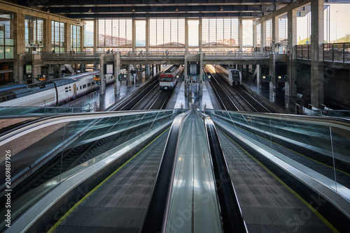 Modern Railway Station Interior with Escalator and Train Platforms