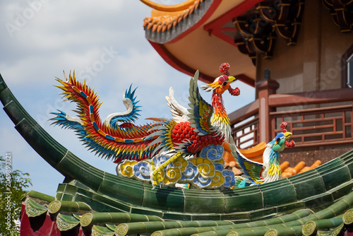 Cuadro en lienzo Colorful phoenix statues adorn the roof of a traditional Chinese temple