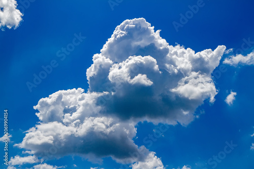 White cumulus cloud against a clear blue sky. Meteorological weather phenomenon and atmospheric background. Nature concept for environmental and climate studies.