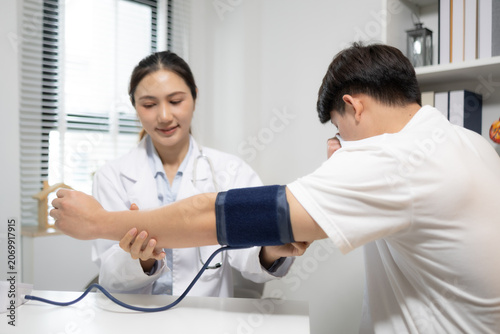 Fotografie Doctor records patient's blood pressure reading