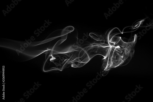 White smoke wisps and swirls isolated on a black background.