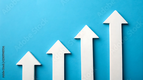 Four white arrows pointing upwards arranged in a row against a bright blue background, representing growth and, progress in business