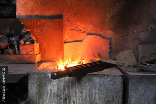 Foto The process of heating metal held with tongs in a traditional blacksmith’s forge
