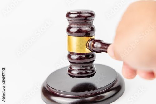 Tableau sur toile Front angle layout of a person hand striking a mahogany judge gavel down on its