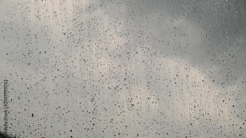 Heavy summer rain outside. Strong wind and rain drops falling on glass window