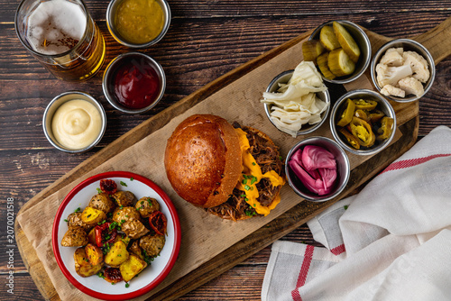 Slow cooked pulled rib beef burger with melted cheese and sides