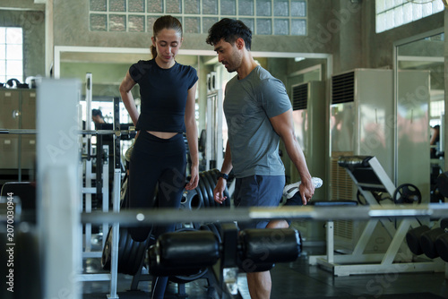 Obraz na płótnie Health enthusiasts are working out and lifting dumbbells in the gym during the holidays