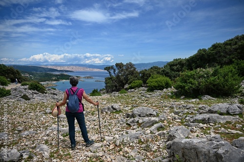 Obraz na płótnie Rear view of senior woman hiking on the mountain with beautiful view on the Adri