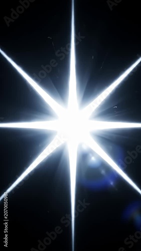 Brilliant white eight-point star flare against black backdrop.