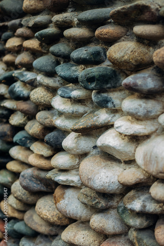 Fotografie Background with the texture of a stone wall made of pebbles