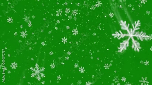 White snowflakes falling against a vibrant green screen background