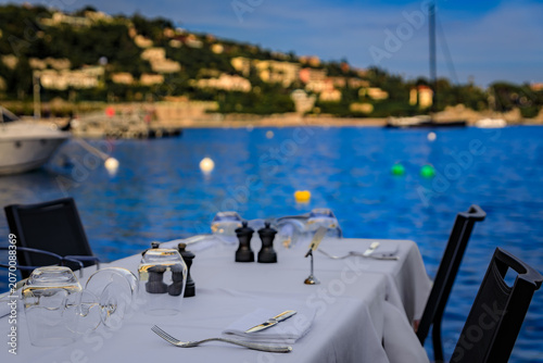 Photos A table at an outdoor restaurant with a view of boats in the marina on the Medit