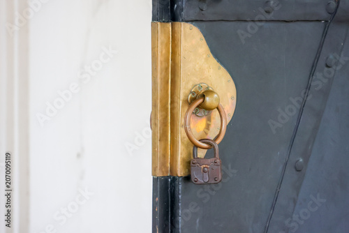Obraz na plátně Rusted lock hangs on aged, blue-painted wooden door