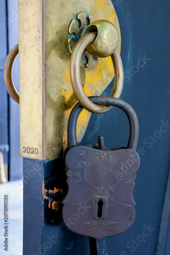 Fotografie Rusted lock hangs on aged, blue-painted wooden door