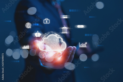 A businessman holds a digital cloud with financial icons, a bank building, a piggy bank, and data charts.