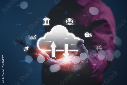 Businessman holding cloud computing technology with digital symbols for banking, analytics, and settings surrounding the central cloud.