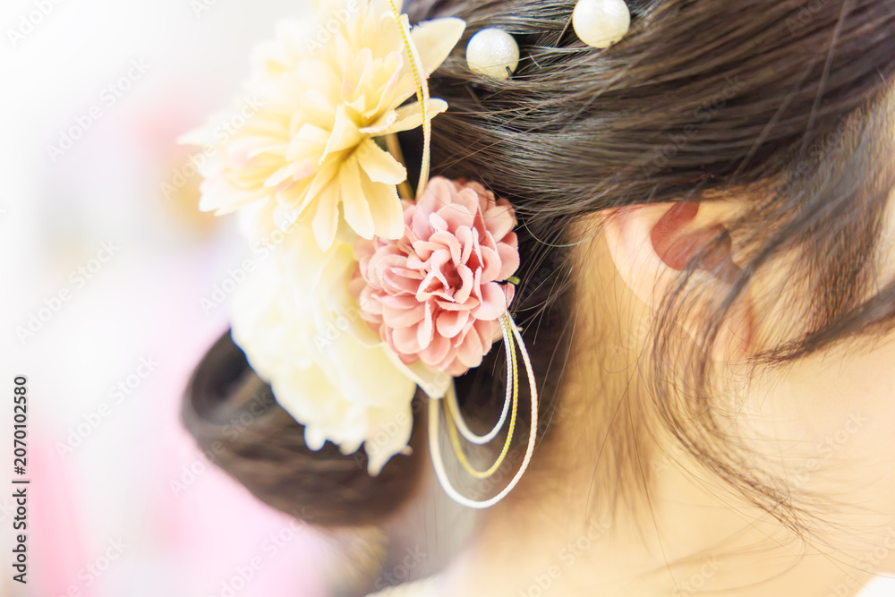 Naklejka premium 華やかな造花の髪飾りをあしらった着物姿の女性のヘアスタイル（後ろ姿）