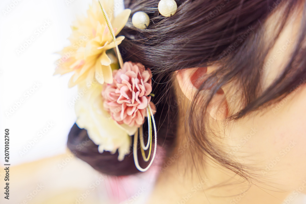 Naklejka premium 華やかな造花の髪飾りをあしらった着物姿の女性のヘアスタイル（後ろ姿）