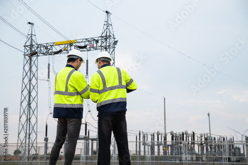 Foto Engineers Reviewing Technical Reports at Modern Electrical Power Grid Installati