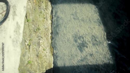 Mossy Stone Drainage Channel Edge With Subtle Water Movement Under Soft Sunlight