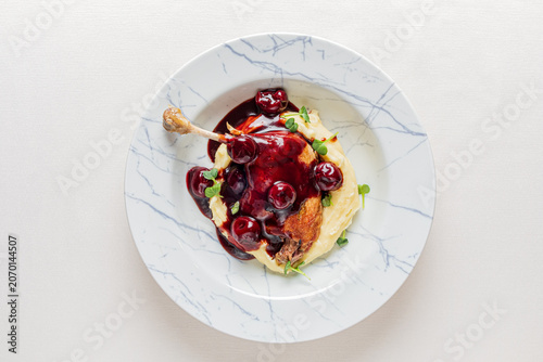 Delicious roasted chicken with cherry sauce served on creamy mashed potatoes