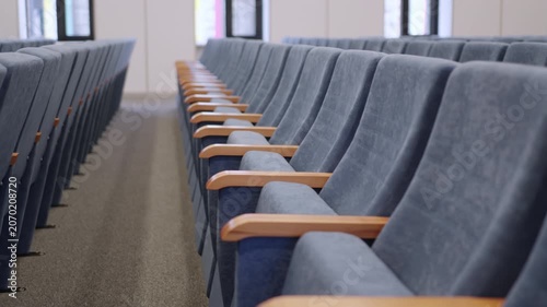 Uniform rows of comfortable conference furniture in lecture hall. Clean layout provides organized and structured academic environment