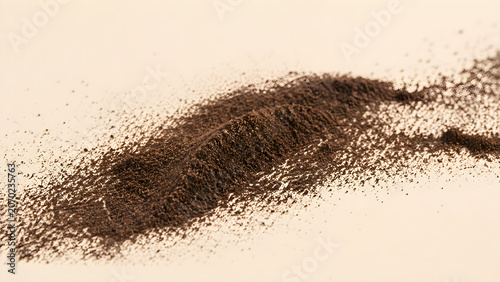 Ground vanilla bean powder scattered on a cream background