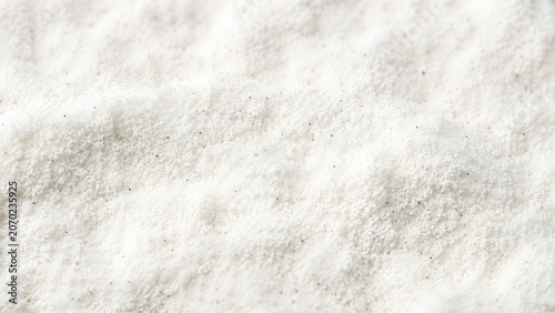 Macro view of fine white vanilla powder with dark bean specks